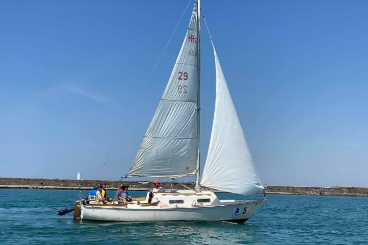 a blue and white boat sitting next to a body of water