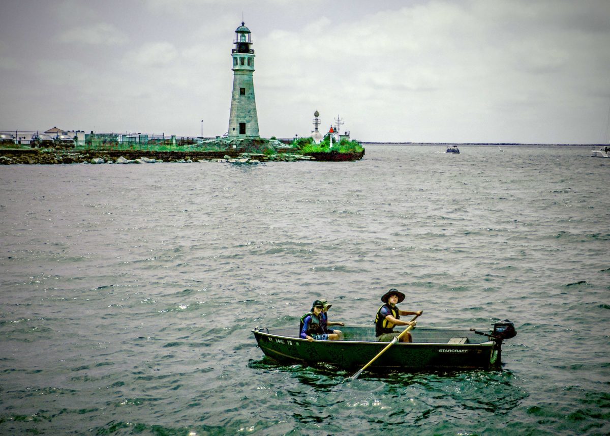 a man in a green boat on a body of water